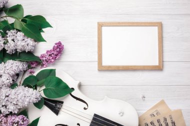 Keman ile leylak, tebeşir Beyaz ahşap bir masa kurulu ve müzik sayfasında bir buket. Senin metin için yer ile en iyi manzaralı.