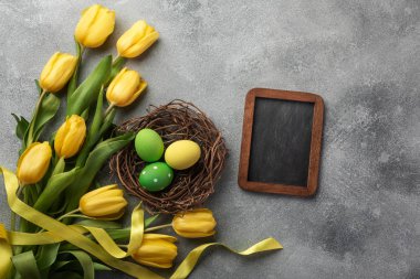 Paskalya arka plan mavi ve pembe yumurta yuva ve sarı laleler ile. Selam yeri olan üstten görünüm