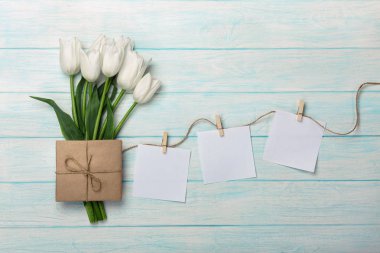 Beyaz Laleler ve zarf ip ve mavi ahşap kurullarında clothespins ile bir sopa ile bir buket