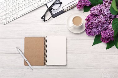 Office Masaüstü leylak, kahve fincanı, klavye, defter ve kalem beyaz tahtalar üzerinde bir buket