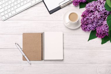 Office Masaüstü leylak, kahve fincanı, klavye, defter ve kalem beyaz tahtalar üzerinde bir buket