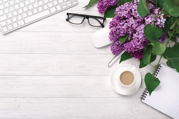 Office Masaüstü leylak, kahve fincanı, klavye, defter ve kalem beyaz tahtalar üzerinde bir buket