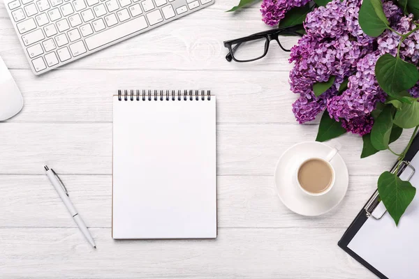Office Masaüstü leylak, kahve fincanı, klavye, defter ve kalem beyaz tahtalar üzerinde bir buket