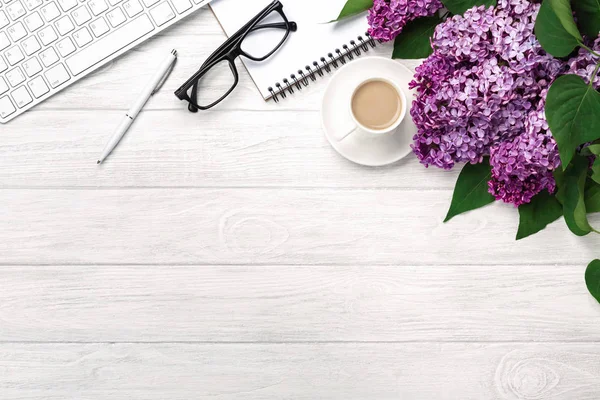 Office Masaüstü leylak, kahve fincanı, klavye, defter ve kalem beyaz tahtalar üzerinde bir buket