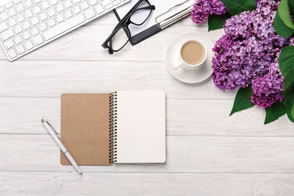 Office Masaüstü leylak, kahve fincanı, klavye, defter ve kalem beyaz tahtalar üzerinde bir buket