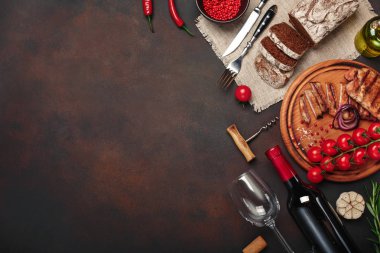 Izgara domuz biftek şişe şarap, Şarap kadehi, tirbuşon, bıçak, çatal, siyah ekmek, domates, sarımsak, soğan ve biberiye ile paslı arka plan üzerine dilimlenmiş