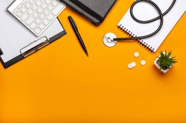 Doktor Resepsiyon stetoskop klavye not defteri ve kalem, reçete ve hapları ile Üstten Görünüm
