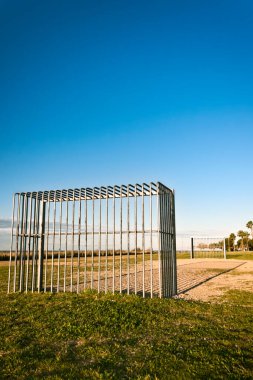 Boş bir futbol sahasında metal goller. Kopya alanı olan mavi gökyüzü.