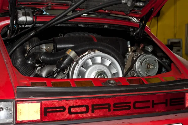 Vigo, İspanya - 18 Şubat 2020: 18 Şubat 2020 tarihinde İspanya 'nın Vigo şehrinde bakım için garajda bulunan Porsche 911 Coupe Carrera G-Modell 915, 1986 model kırmızı bir arabanın motoru.