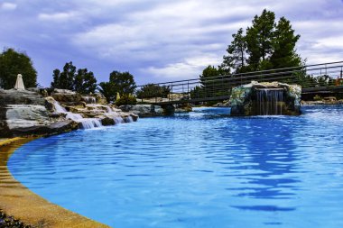 Resort, Yüzme Havuzu ile Yunanistan beldesinde mavi su temizleyin. Yapay şelaleler benzersiz, kendine özgü bir manzara oluşturun. Ağaçlar ve çalılar etrafında büyümek.