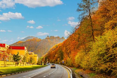 Güzel bulutlar, göz kamaştırıcı güneş ve sonbahar ağaçlarının parlak renkleri Rosa Khutor 'un yüksek rakımlı tatil beldesinde.