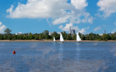 Yelkenli yarışını kazanmak için hız, manevra kabiliyeti, yelken kontrolü ve rüzgar kontrolü. Irty 'de her yıl olan bir şey. Güzel bulutlar nehrin sakin yüzeyine yansıyor..