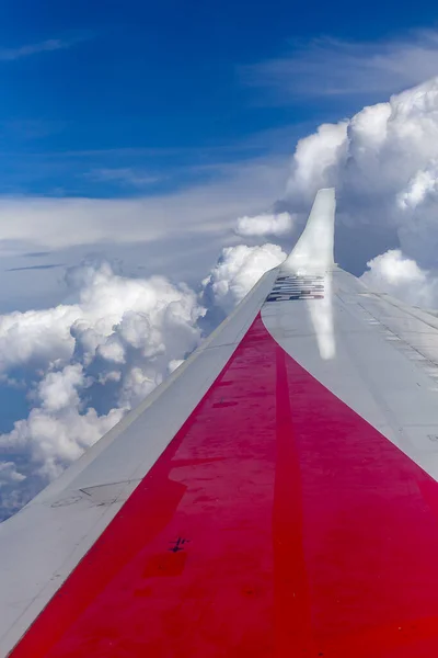 Uçağın kanatları altında, beyaz kabarık ve karanlık bulutlar yüzer, güneşin arzusundan renklerini değiştirirler.