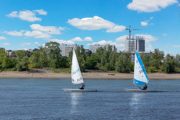 Yelkenli yarışını kazanmak için hız, manevra kabiliyeti, yelken kontrolü ve rüzgar kontrolü. Irty 'de her yıl olan bir şey. Güzel bulutlar nehrin sakin yüzeyine yansıyor..