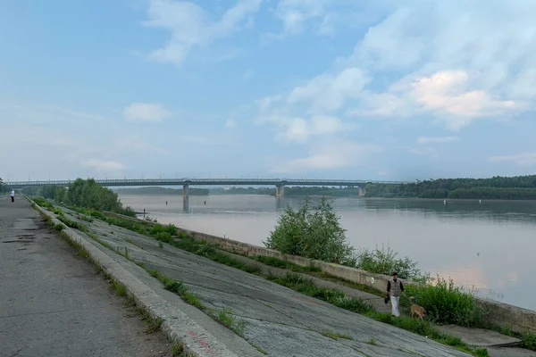 Antik Sibirya nehri Irtysh 'in sakin sabah sularına yansıyan açık beyaz bulutlar gemilere eşlik ediyor ve Omsk şehrinin yanından geçiyor.