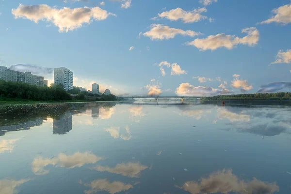 轻飘飘的白云映照在古代西伯利亚伊尔季什河平静的早晨的水面上 护送船只驶过奥姆斯克市 — 图库照片