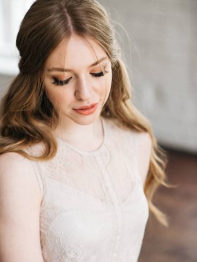 Öğe, dikey, genç güzel kadın şık makyaj ve saç modeli aşağı bakıyor doğal ışık