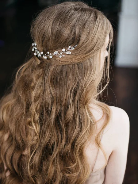 Portrait of pretty young woman with beautiful hairstyle decorated by stylish hair accessory, rear view