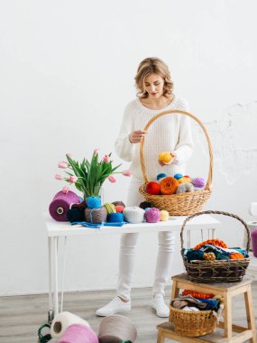 Genç ve güzel kadın yünlü giysiler dokuma kumaşlar. Örgü iğneleri ve yün iplik ile kız