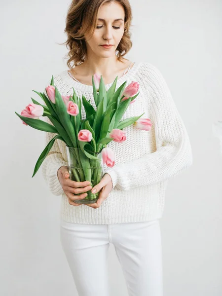 Молодая Женщина Держит Красивую Кучу Розовых Тюльпанов Руках Белой Стены — стоковое фото