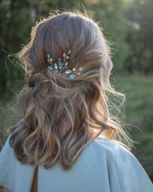 Mavi elbise ve mavi elmas taklidi saç aksesuarı yaz alanında giyen saç modeli ile güzel bir kadın portresi 