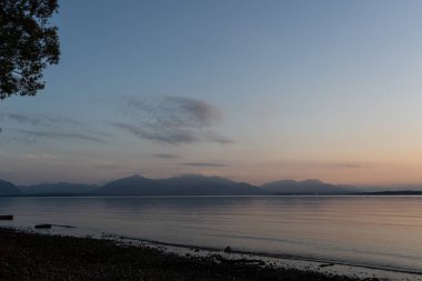 Gün batımında arka planda dağlar ile Chiemsee göl