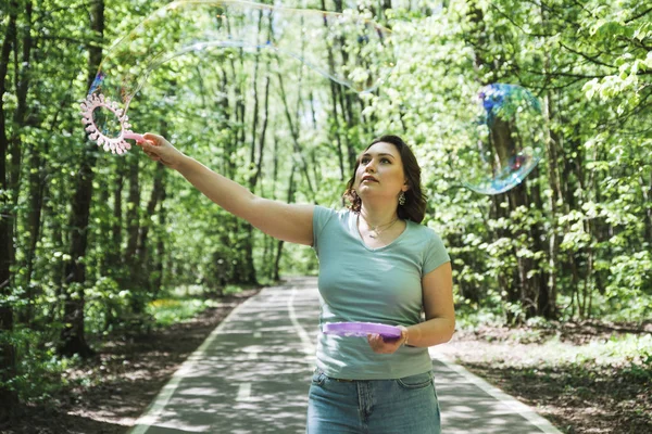 Young plus size woman blowing soap bubbles — Stock Photo, Image