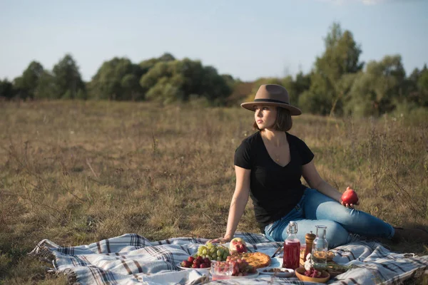 Pretty young woman enjoying picnic in sunny autumn field — Stock Photo, Image