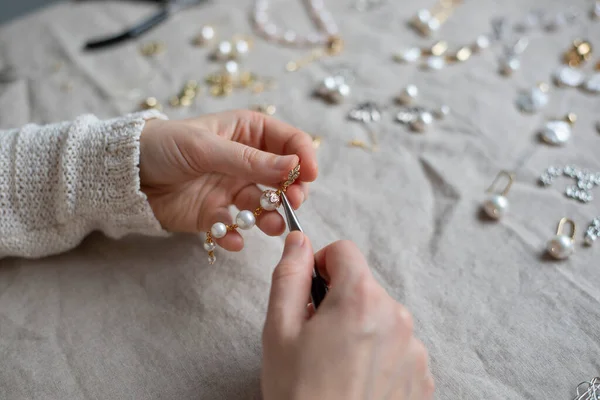 Jewelry designer working in studio with tools, materials and jewelry items