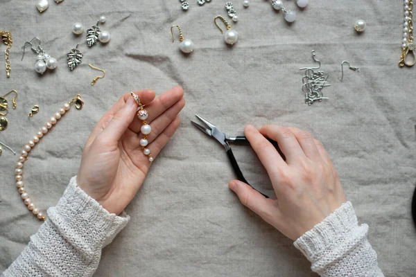 Jewelry designer working in studio with tools, materials and jewelry items