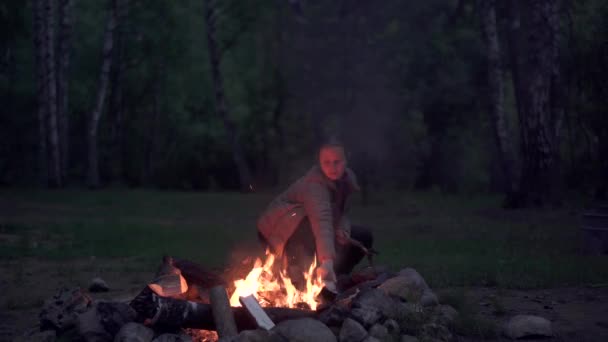 Mujer haciendo hoguera por la noche en el bosque — Vídeo de stock