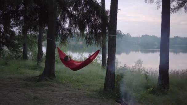 Genç Bir Kadın Göl Kıyısındaki Ormanda Hamakta Dinleniyor — Stok video