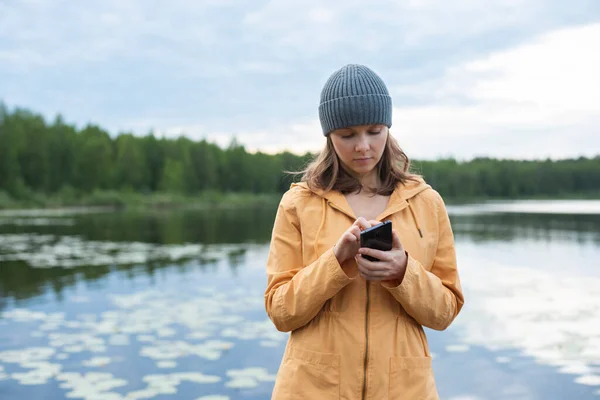 Kvinna Som Använder Smartphone När Står Vid Sjön Mot Molnig — Stockfoto