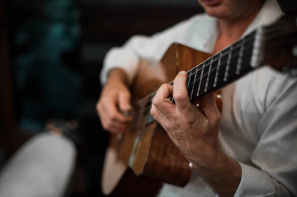 Bir adam gitar çalıyor. Eller erkekler kapatın. Akustik gitar.