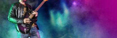 Gitarist sahnede çalıyor. Rock gitaristi elektro gitarda solo çalar. Sanatçı ve müzisyen rock yıldızı gibi şarkı söylüyor. Siyah beyaz versiyonu. Yeşil ve ihtiyatlı versiyonu. Panoramik resim.