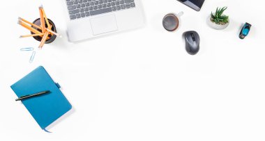 Kahve, akıllı telefon, dizüstü bilgisayar ve not defteri olan üst düzey bir ofis. Beyaz masada yukarıdan işyeri manzarası. Alanı beyaz arkaplan biçiminde kopyala.