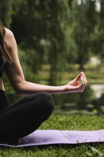 Yoga in the park. Woman in lotus position outdoor, yoga hand gesture. Healthy lifestyle concept