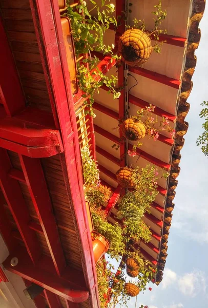 Beautiful traditional Colombian red balcony with typical colonial architecture and decorated with tropical flower pots