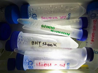 Konik Plastik tüpler farklı birimler ve kapasitelerde işaretler ile mavi vidalı kapakları ve Etiketler yan aydınlatma ile bir çekmecede kimyasal maddelerin koleksiyonu. Bilimsel bir laboratuvar kimyasalları depolanmasını.