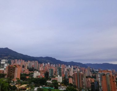 Lüks ve özel El Poblado mahallenin Medellin, Kolombiya, yüksek binalar ve dağlık yeşil alanlar ile akşam görünümü