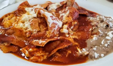 Lezzetli chilaquiles, tipik Meksika yemeği fasulye, peynir ve sıcak domates sosu geleneksel tortilla.