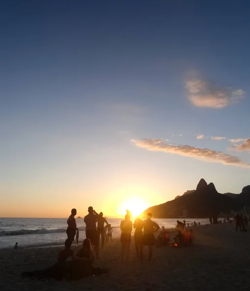 その特徴的な山で ジャネイロ ブラジルの美しいコパカバーナ ビーチに沈む夕日 ビーチで楽しんで 太陽の光とバックライトします — ストック写真