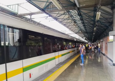 Bir grup insan Medellin Metro bir trene binmeye, yolcu. 