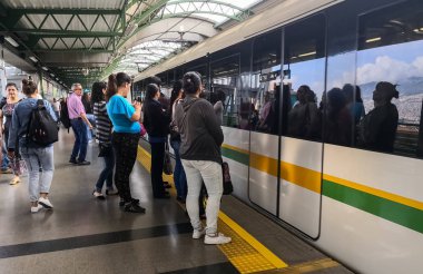 Yatılı veya metro bırakarak için bekleyen yolcular Medellin Metro (Kolombiya) Tren İstasyonu platformu.
