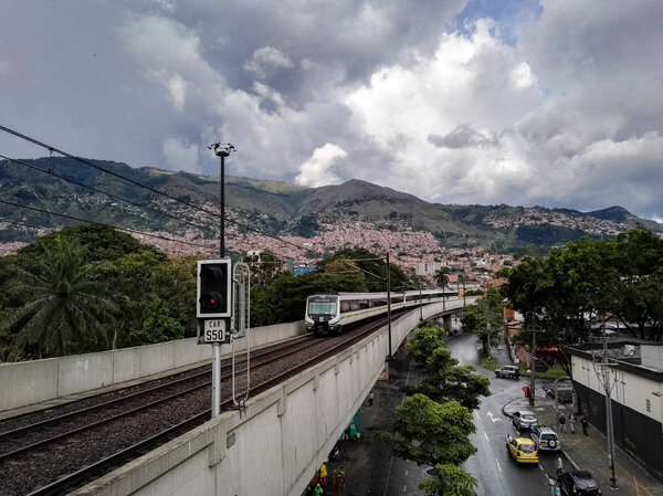 View of the Medellin Metro, Colombia. Elevated train over the city, mass public transport. View of the mountains and buildings of this Colombian city.