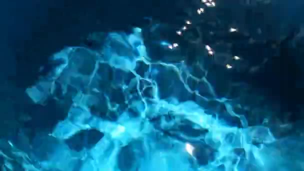 blaues Wasser im Zeitraffer mit hellen Lichtreflexionen, Wellen und abstraktem Hintergrundkonzept