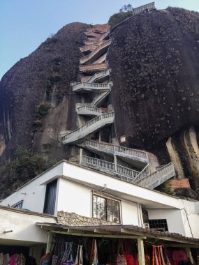 The Rock of Guatape, El Pen de Guatape. Stone of El Peol or La Piedra de El Peol. Landmark inselberg and monolith in Antioquia, Colombia. Tourist site with detail of stairs leading to the top of the rock. clipart