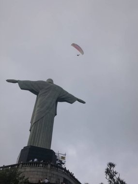 Görkemli Mesih'in kurtarıcı ve üzerinde uçan bir yamaçparaşütü görüntüleyin. Turizm ve Rio de Janeiro, dini sembol bulunan meşhur mekanlar.