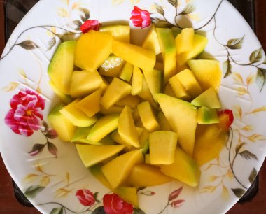 Üstten görünüm adet mango ile bir plaka. Lezzetli tropikal meyve, sulu ve sarı. Sağlıklı beslenme ve vitamin dolu.