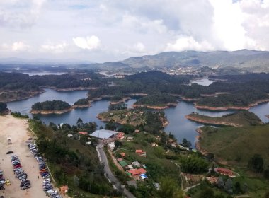 Arabalar ve Guatape gölleri ulaşım ve Peol kaya tırmanışı turist otopark. Dağlar, su ve bazı turist ya da yaz villalar görünümünü